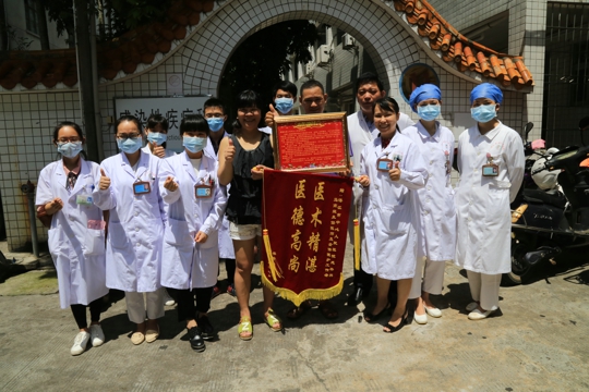 梁先锋与莫女士给感染内科医务人员送来感谢的锦旗（翁冬宁摄）
