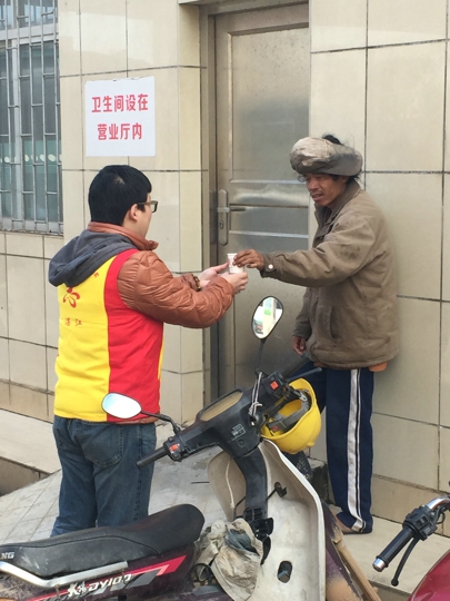 刘健航给一流浪汉送姜糖水（陈蔚攀摄）